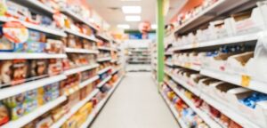 Food and drink supplier reviewing category data on a tablet in a retail aisle.