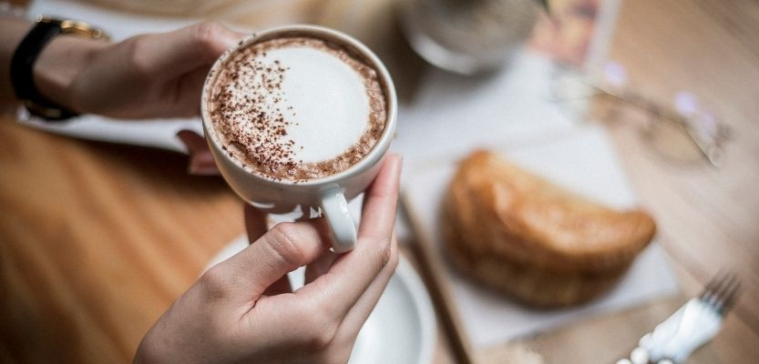 Cup of coffee on a café table, illustrating social media content created without clear content marketing strategies or customer focus 