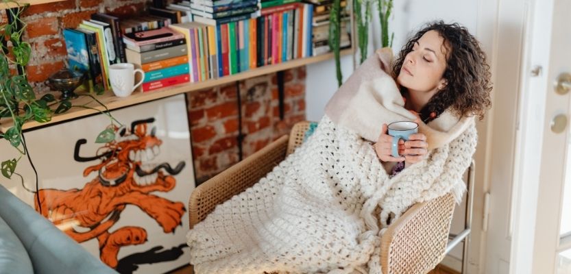 Person resting with tea and tissues, showing how effective content marketing strategies focus on benefits rather than features
