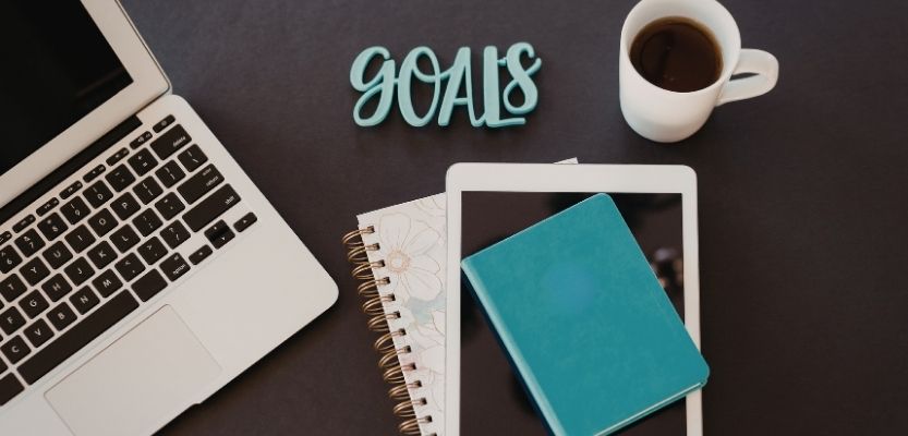 Planning email content with a notebook and laptop