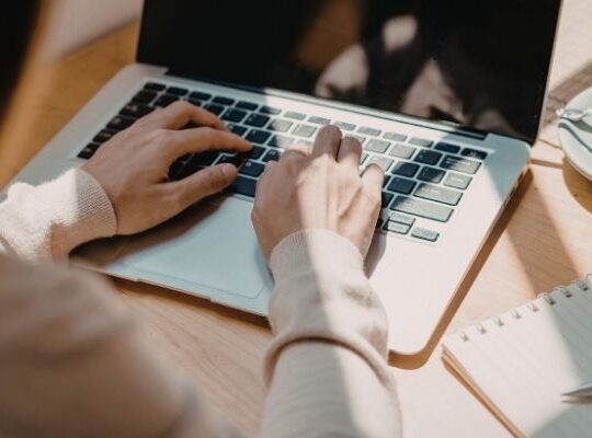Small business owner reviewing email marketing notes at a kitchen table