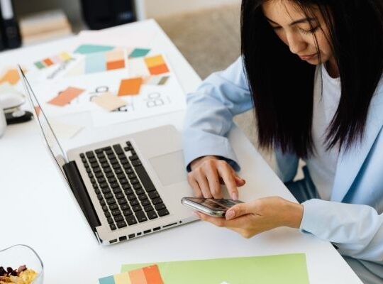 Business owner reviewing marketing tasks on laptop looking thoughtful.