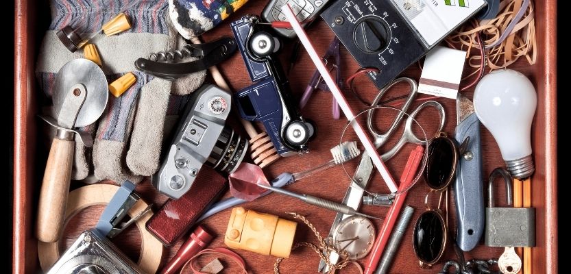 Messy drawer filled with random household items representing disorganised ideas