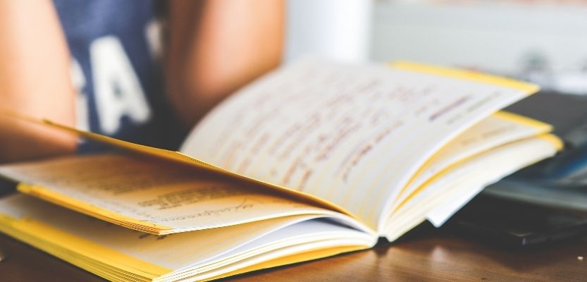 Notebook containing handwritten marketing questions ready for review.
